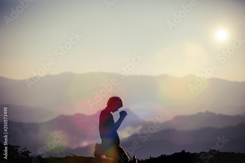 Faith of christian concept: Spiritual prayer hands over sun shine with blurred beautiful sunset background