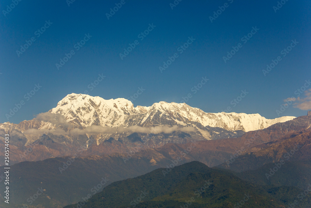 green hill in the background of the Annapurna desert snow mountain under a clear blue sky. Himalayas Nepal