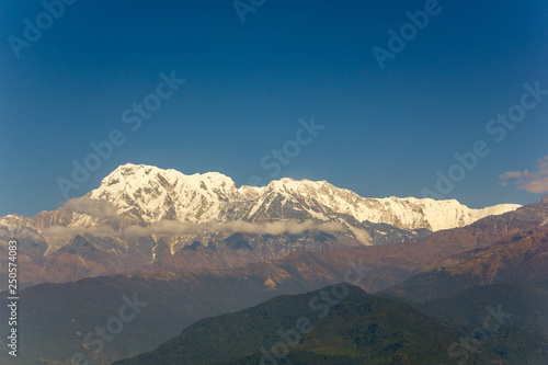 green hill in the background of the Annapurna desert snow mountain under a clear blue sky. Himalayas Nepal
