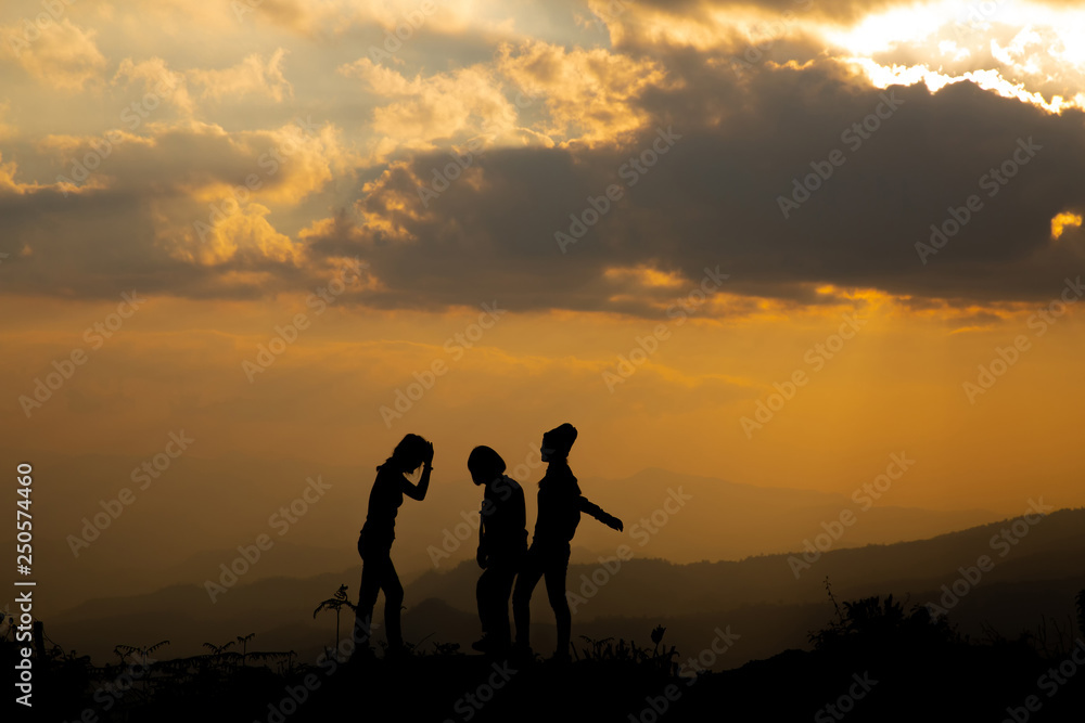 Silhouette, group of happy girl playing on hill, sunset, summertime