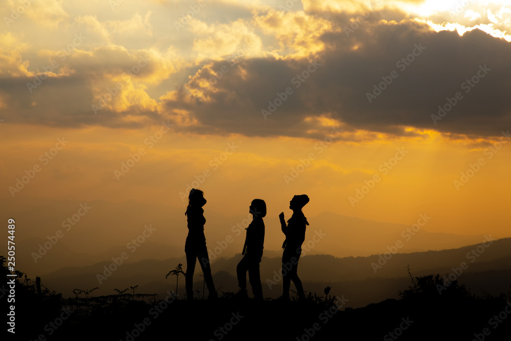 Silhouette, group of happy girl playing on hill, sunset, summertime