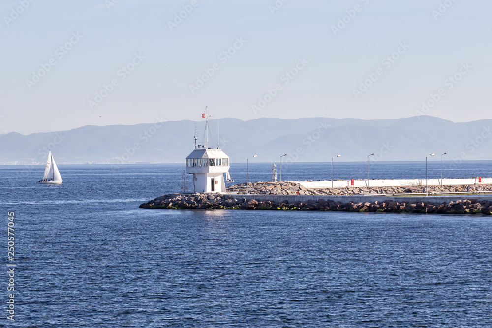 Pier with lighthouse and yacht in sea of Bosphorus