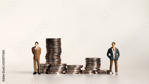 A pile of coins and miniature people. Business concept.