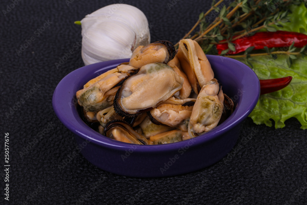 Pickled mussels in the bowl served pepper, garlic and salad Pickled mussels in the bowl served pepper, garlic and salad