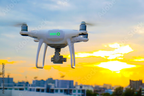 UAV drone flying over city building colorful sunset