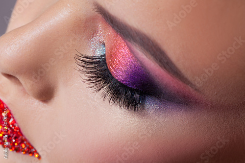 Bright eye makeup and red lips in rhinestones. Pink and blue color, colored eyeshadow.