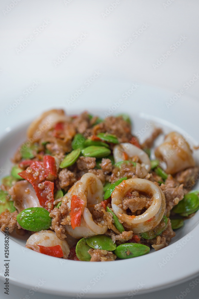 Stir-Fried Twisted Cluster Bean with squid/Bitter Bean on a White Dish Stir-Fried Twisted Cluster Bean with squid/Bitter Bean on a White Dish