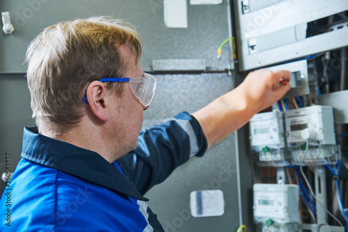 Tableau sur toile Electrician works in fuse box. Switching of circuit breaker