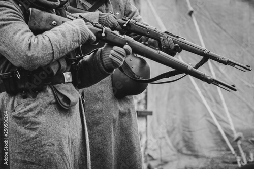 Fotografie, Obraz Two German soldiers of the Second World War with rifles in their hands ready to fire