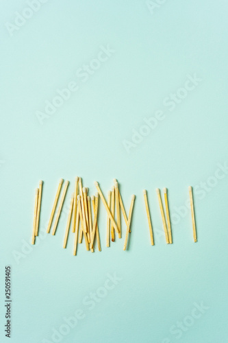 Wooden matches scattered on a turquoise pastel color background