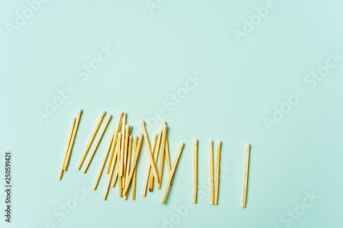 Wooden matches scattered on a turquoise pastel color background