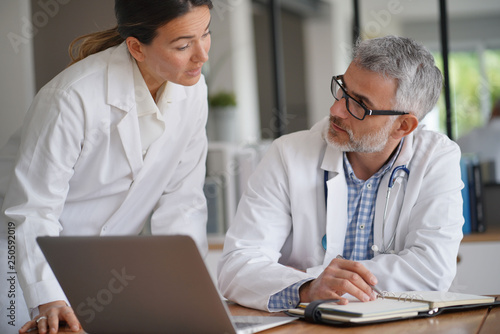 Medical people working together on patient file, hospital office