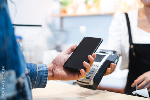 Customer using credit cart for payment to owner at cafe restaurant, cashless technology and credit card payment concept