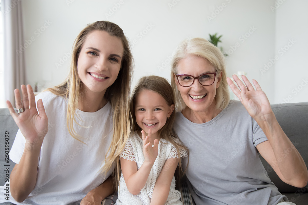 Φωτογραφία Happy smiling little girl with mother and grandmother waving hand