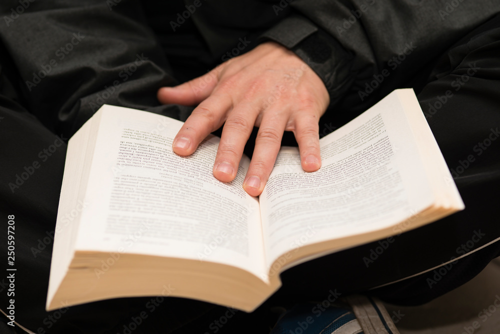 Man hands holding a book with dog-ears. Man hands holding a book with dog-ears.