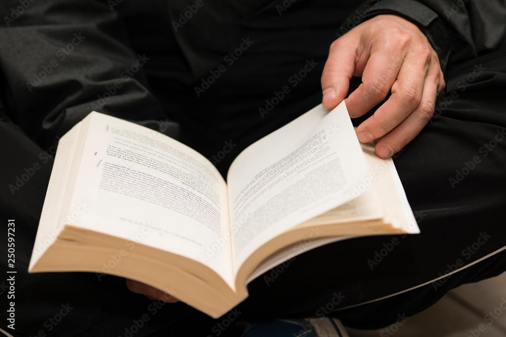Fototapeta premium Man hands holding a book with dog-ears.