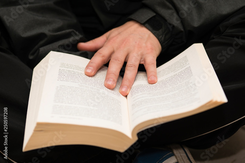 Man hands holding a book with dog-ears.