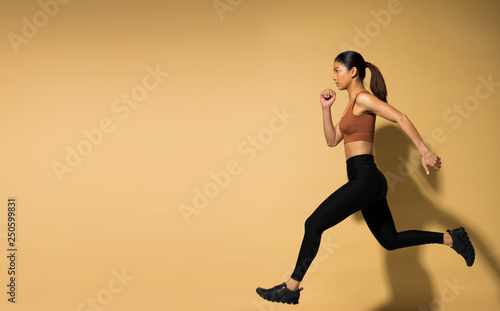 Asian slim Fitness woman exercise warm up stretch arms legs, planking, studio lighting yellow beige mustard background shadow copy space, concept Woman Can Do athlete Sport 6 packs