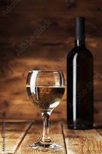 Wine bottles with glass, wooden background