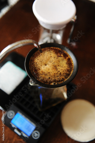 Coffee blooming in porous ceramic paperless filter. Alternative brewing. Gooseneck, electronic scales, manual grinder photo