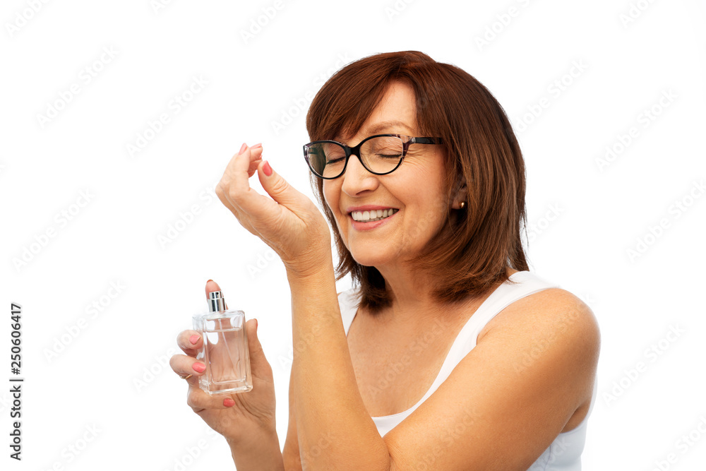 perfumery, beauty and luxury concept - happy smiling senior woman smelling perfume from her wrist over white background perfumery, beauty and luxury concept - happy smiling senior woman smelling perfume from her wrist over white background