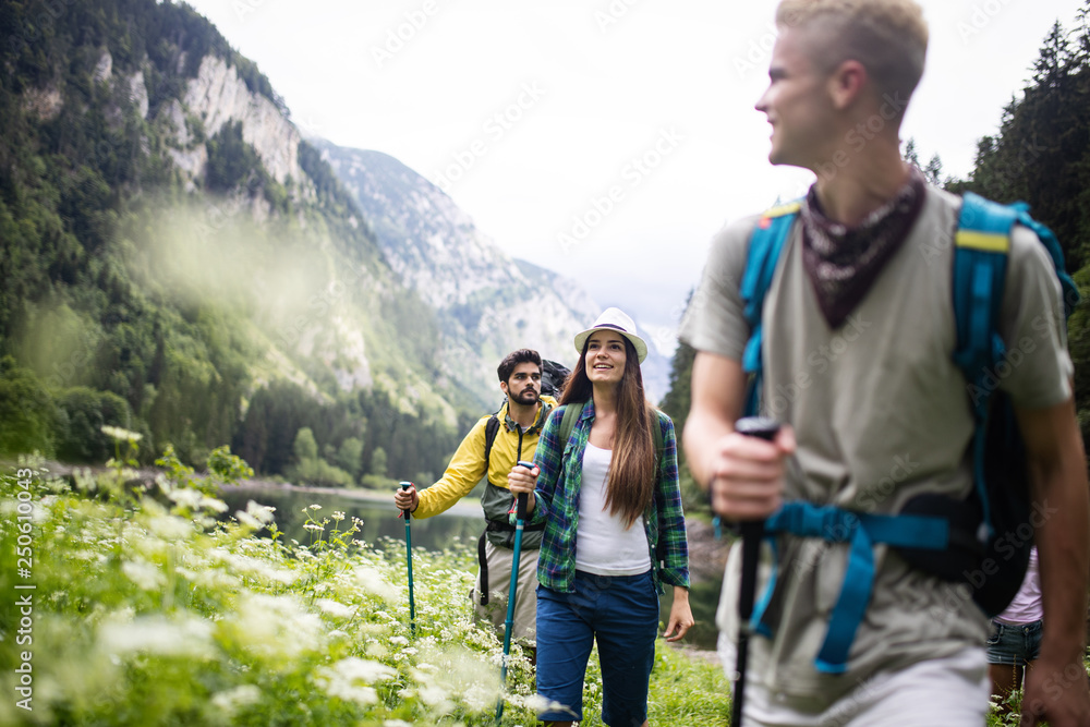 Group of young friends hiking in countryside. Multiracial happy people travelling in nature