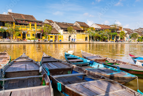 Boats tied on the dock along the riverbank of the Thu Bon River in the Old Quarter of Hoi An (Hội An), Vietnam. Hoi An is a popular tourist destination in central Vietnam. photo