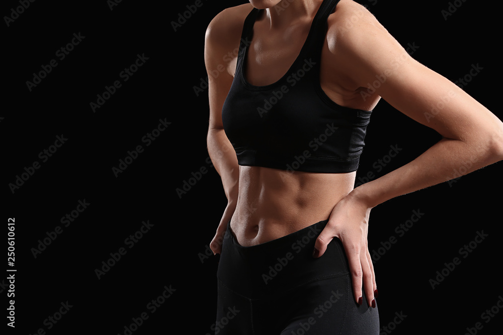 Sporty young woman on dark background