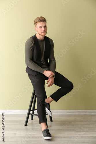 Fashionable young man sitti...