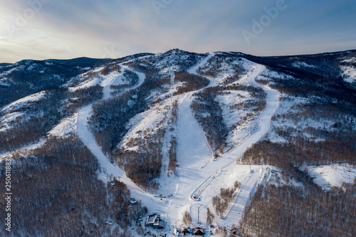 Aerial panoramic view of local famous ski resort; sportive routes with different complexity levels; active leisure time concept; modern cabel car system in provincial town; healthy winter lifestyle