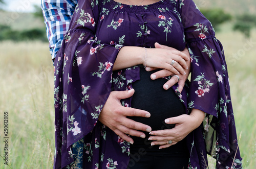 A close up of a couple holding the woman's pregnant tummy
