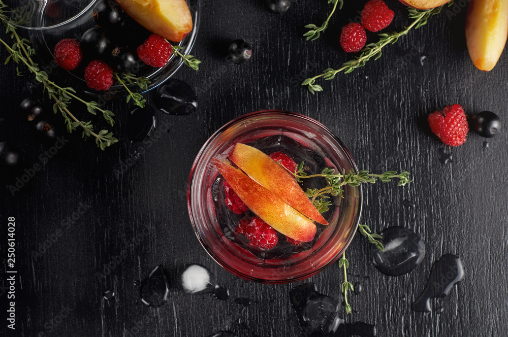 Raspberry thyme gin and tonic cocktail with blackcurrant and peaches