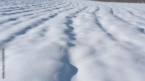 Above the snow zastrugi on the ground 4K drone video photo