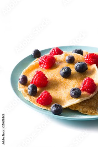 Pancakes with raspberries, blueberries and honey isolated on white background
