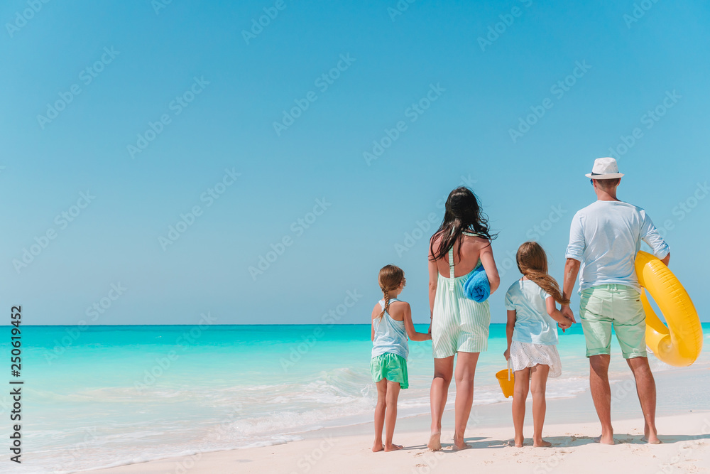 Happy family with kids walk on the beach at sunset