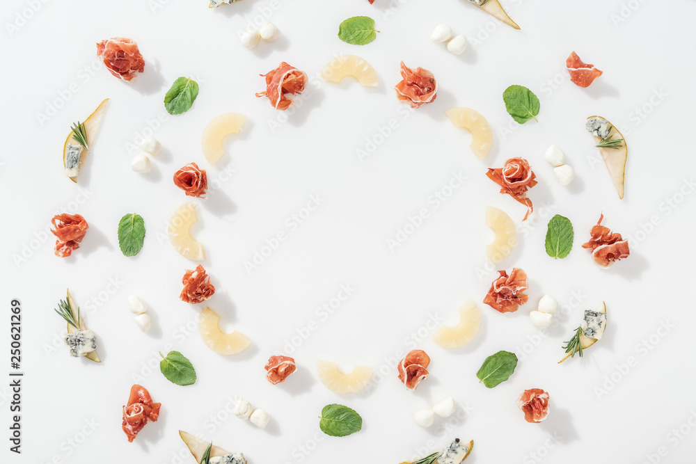 flat lay of prosciutto near sliced pineapples and organic ingredients on white background flat lay of prosciutto near sliced pineapples and organic ingredients on white background