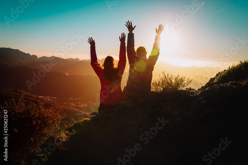 Silhouettes of happy couple enjoy travel at sunset mountains