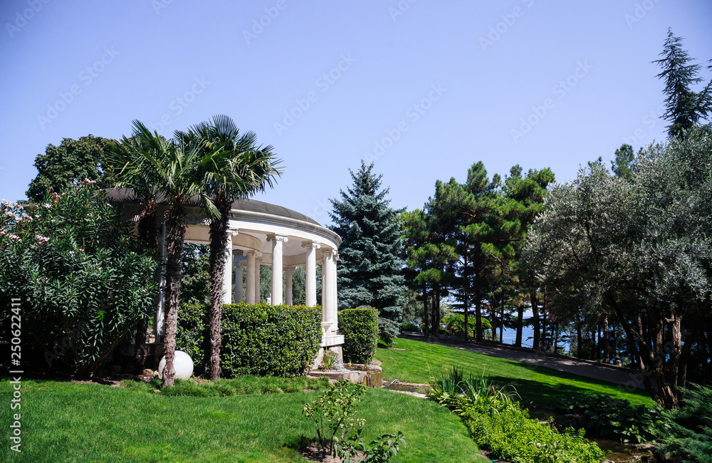 Obraz premium Antique-style gazebo in an olive grove near the pond, Crimea