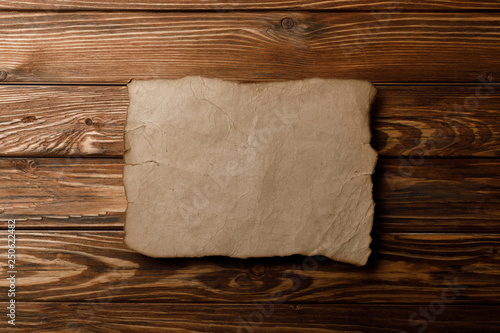 brown old parchment paper lying on wooden background