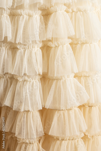 Tulle beige luxury dress with ruffles. Closeup detailed background.