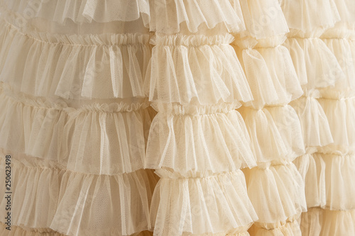 Tulle beige luxury dress with ruffles. Closeup detailed background.