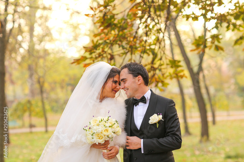 Elegant bride and groom posing together outdoors on a wedding day