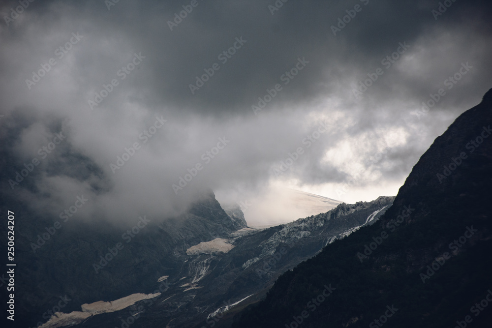 Peaks of Dombai mountains in summer rain clouds Peaks of Dombai mountains in summer rain clouds