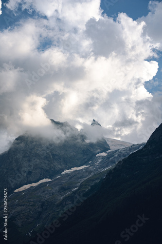 Peaks of Dombai mountains in summer rain clouds