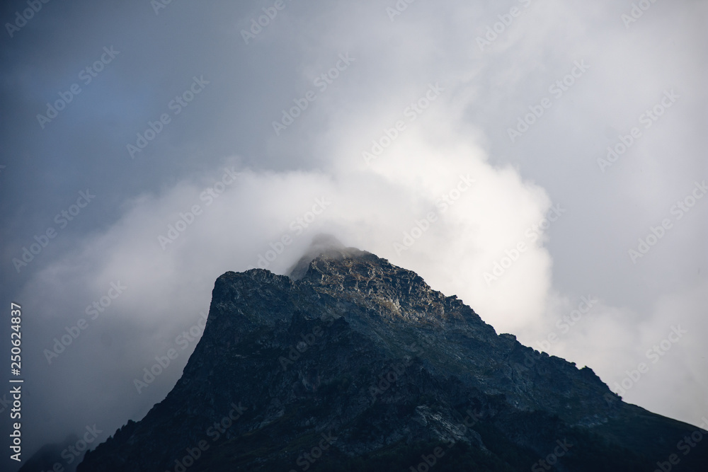 Peaks of Dombai mountains in summer rain clouds Peaks of Dombai mountains in summer rain clouds