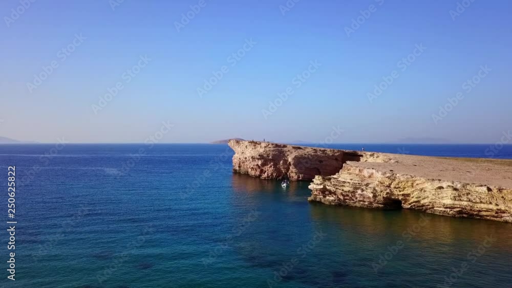 Aerial drone view video of beautiful volcanic caves of Xylobatis or Ksylobatis with deep blue waters, Koufonissi island, Cyclades, Greece