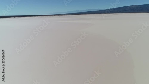 Aerial drone scene of arid dry barreal desert in aimogasta, la rioja, argentina. Camera moving backward and up discovering landscape. Mountains on the background. photo