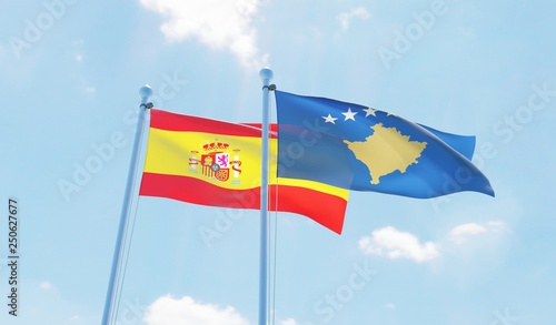 Kosovo and Spain, two flags waving against blue sky. 3d image