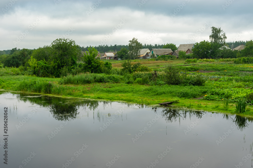 Fototapeta premium Summer gloomy landscape with Kotelva river in Kotelva village, Poltavskaya oblast, Ukraine