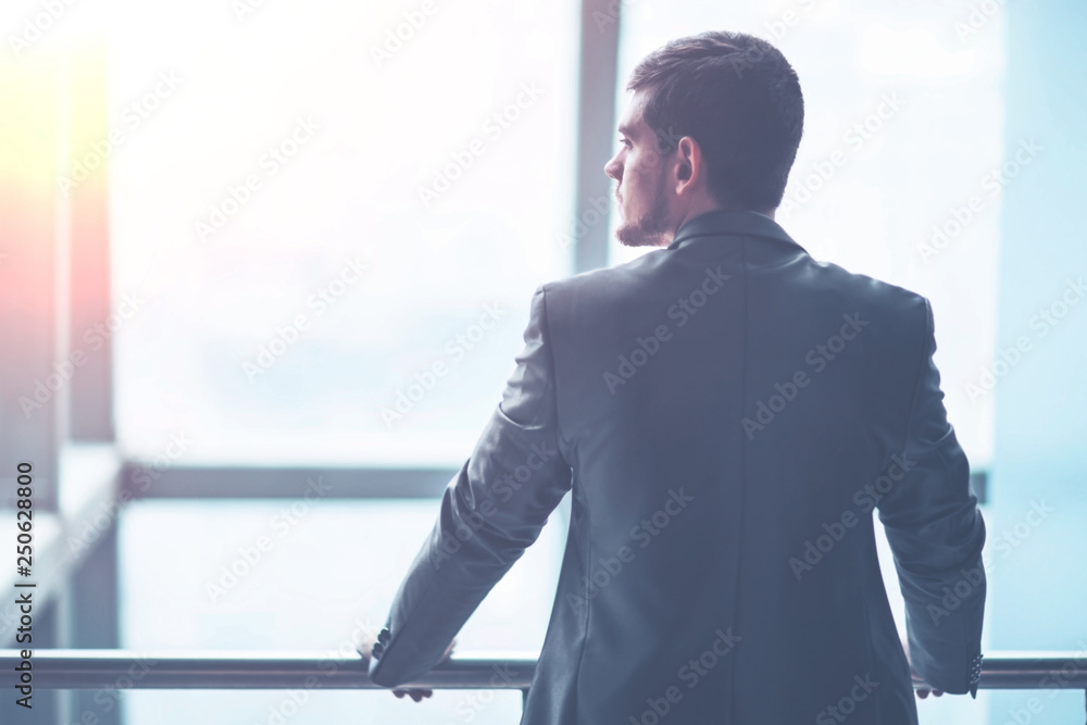 Portrait of a successful handsome businessman in front of a window, there is an empty space for text Portrait of a successful handsome businessman in front of a window, there is an empty space for text